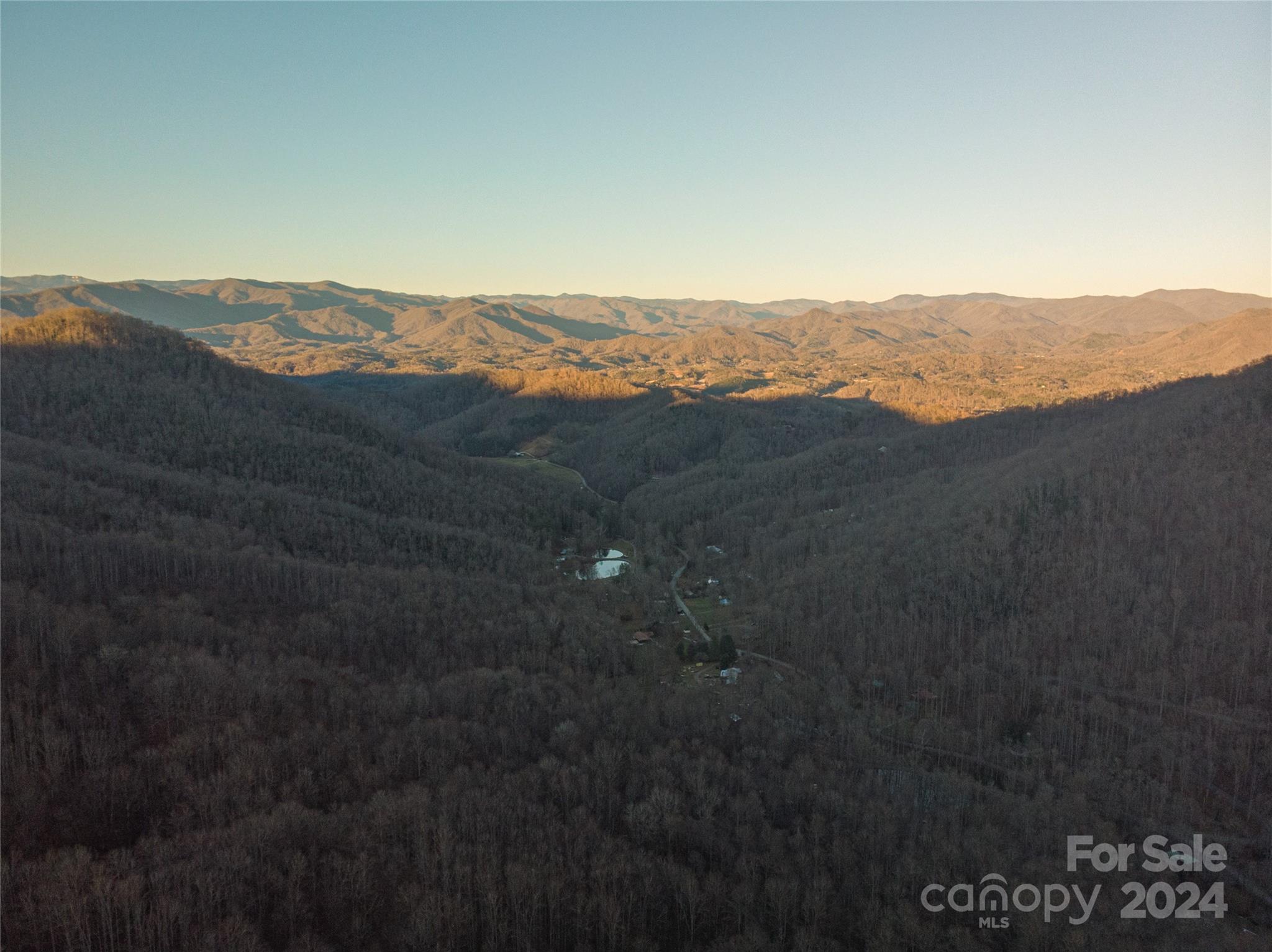 a view of mountain with sunset in background