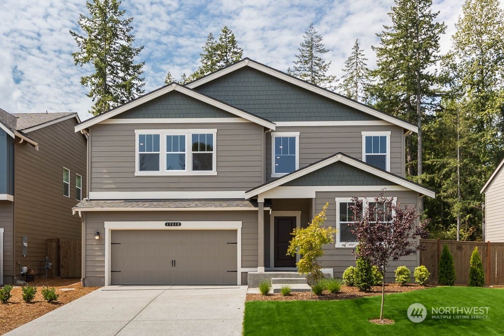 a front view of a house with a yard and garage