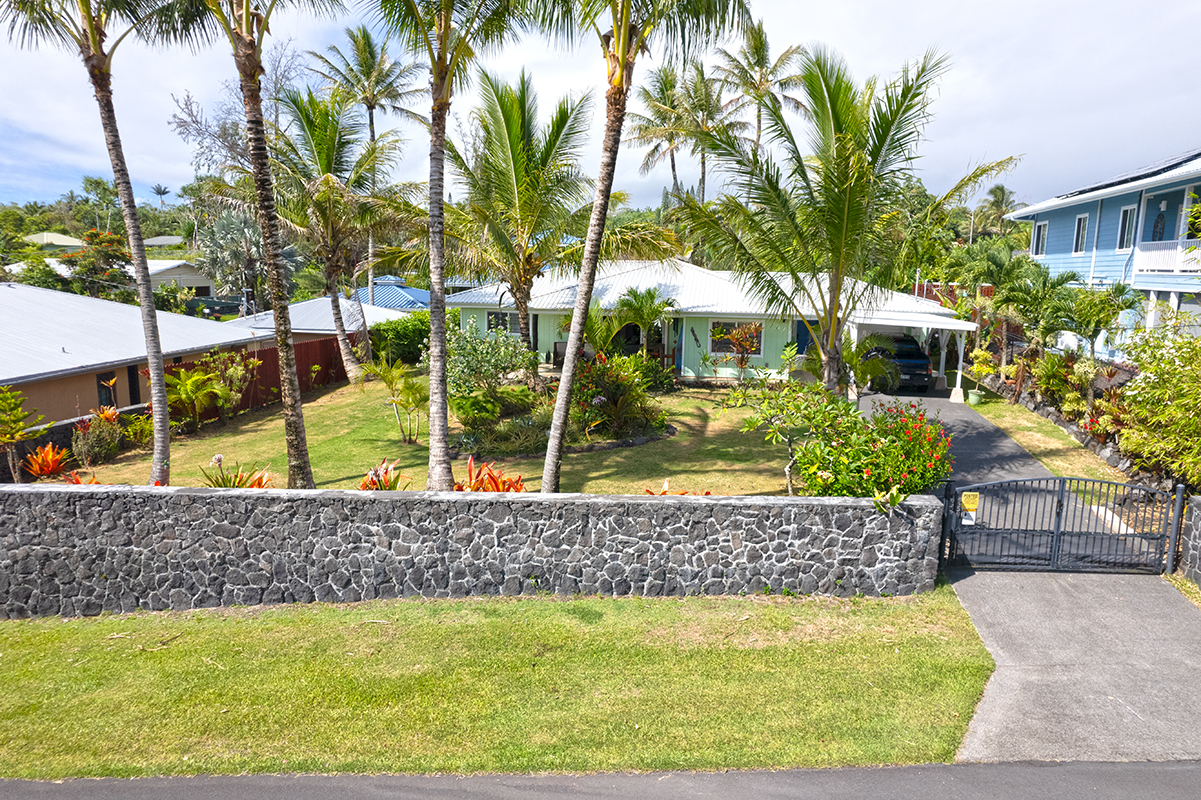 a view of a house with a yard and potted plants