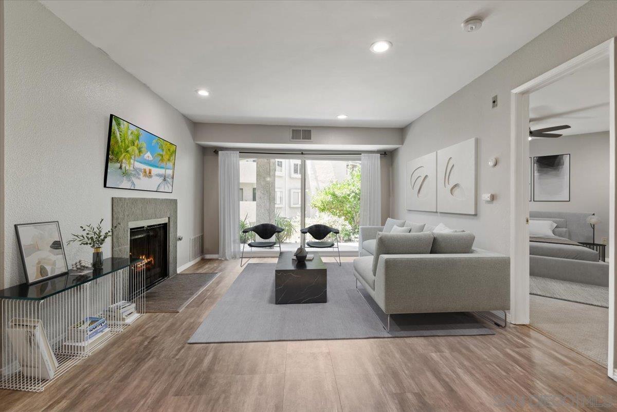 a living room with furniture large window and fireplace