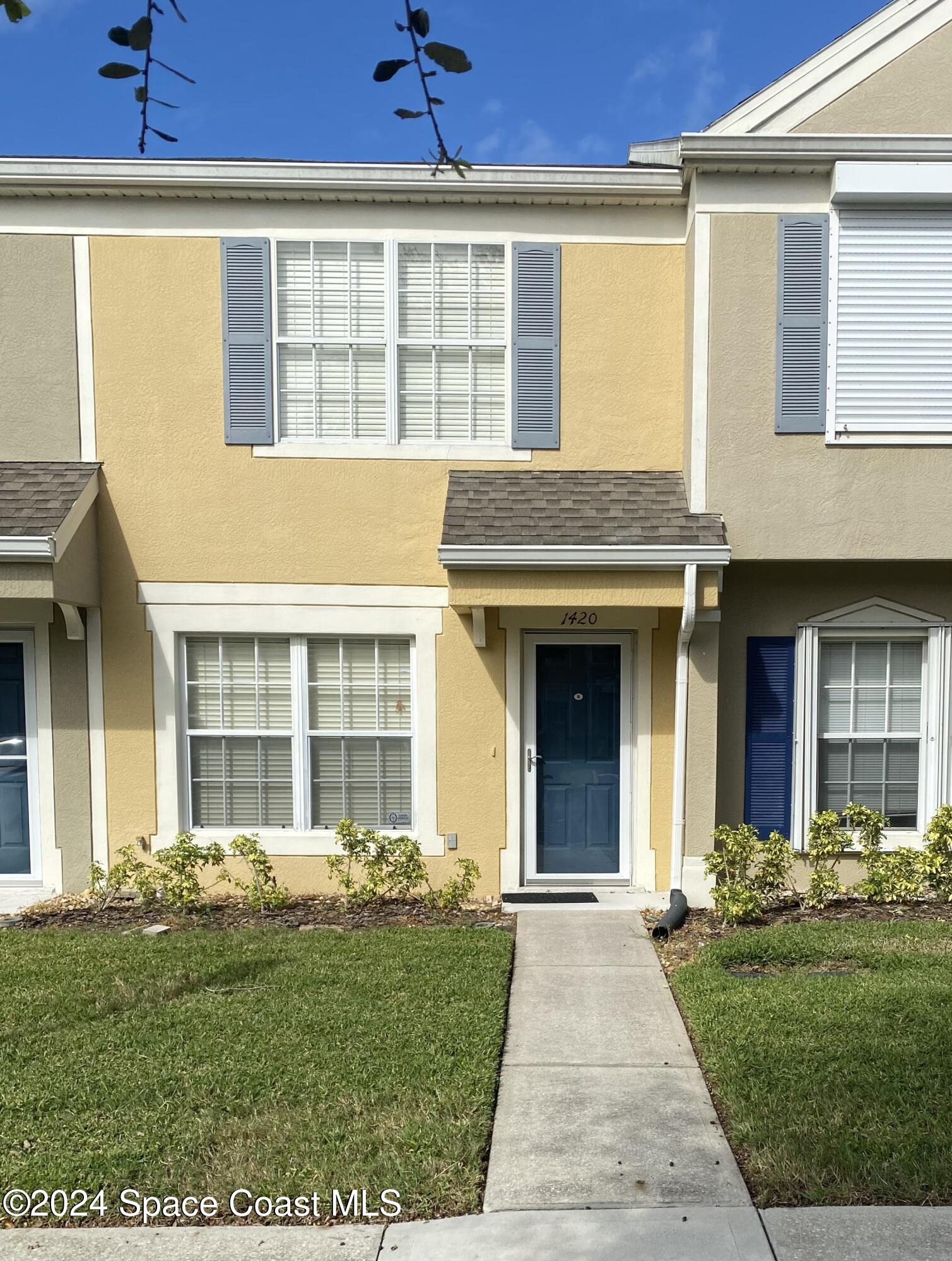 front view of a brick house with a yard