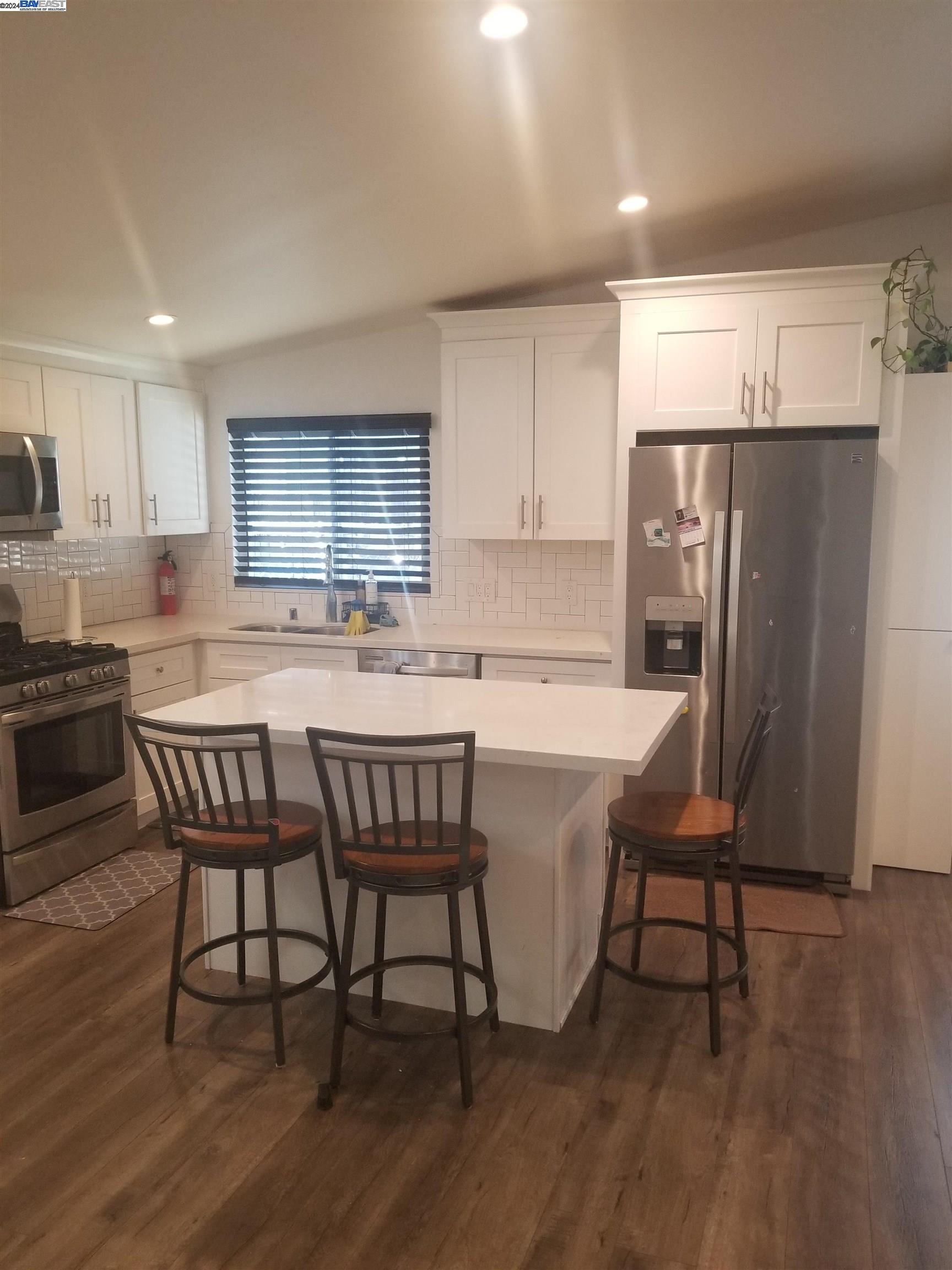 a kitchen with a table chairs refrigerator microwave and cabinets