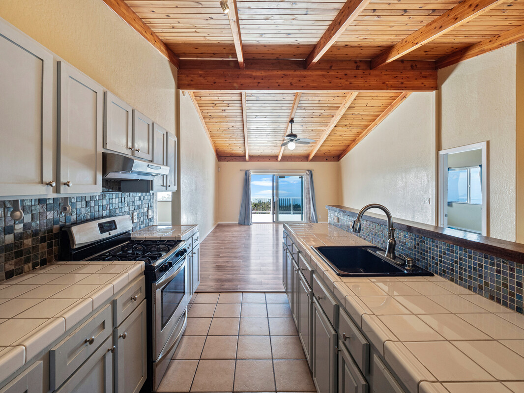 a kitchen with stainless steel appliances granite countertop a sink a stove and a wooden cabinets