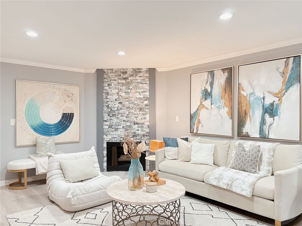 a living room with fireplace furniture and a large window