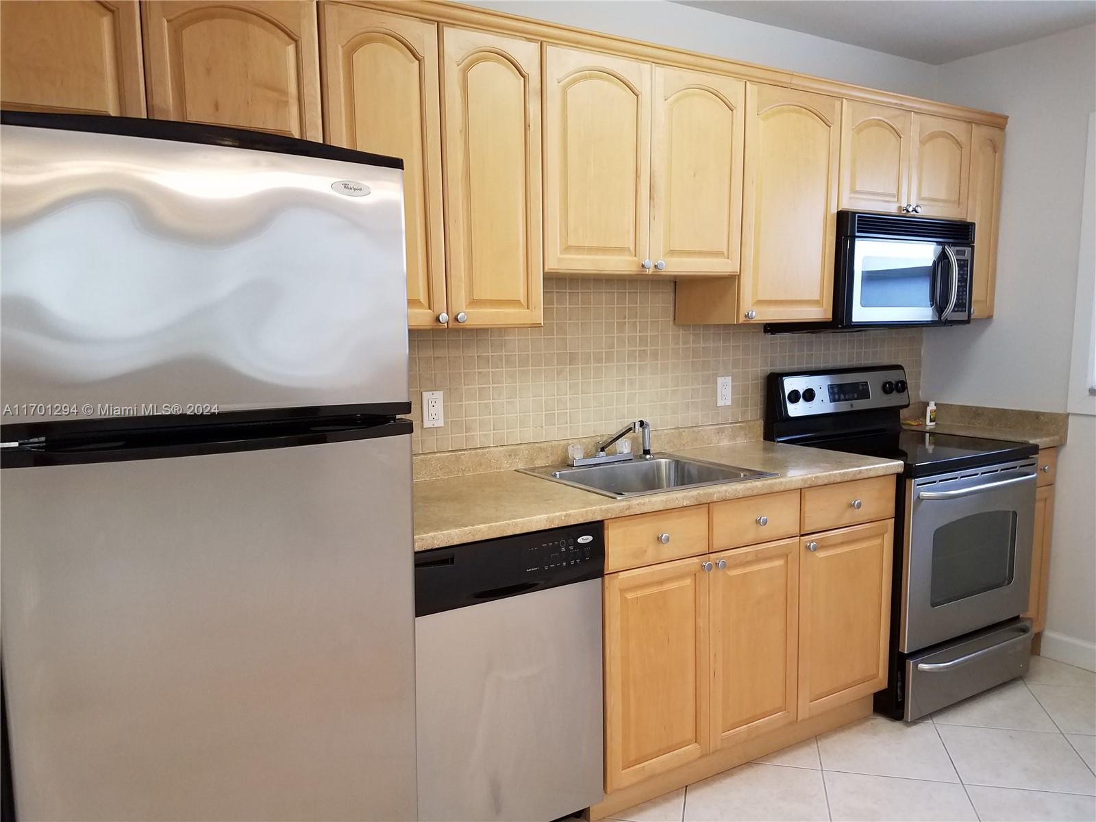 a kitchen with stainless steel appliances granite countertop a sink a stove and a microwave