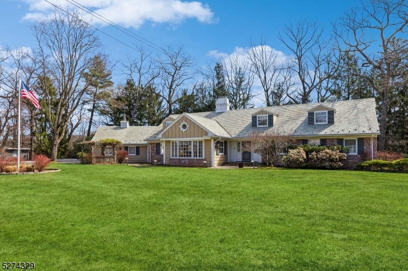 a view of a big house with a big yard and large trees