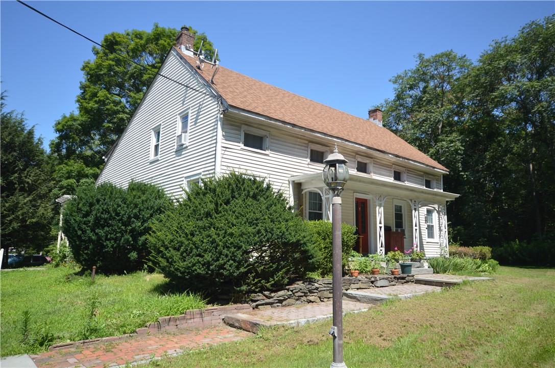 a view of a white house with a yard and plants