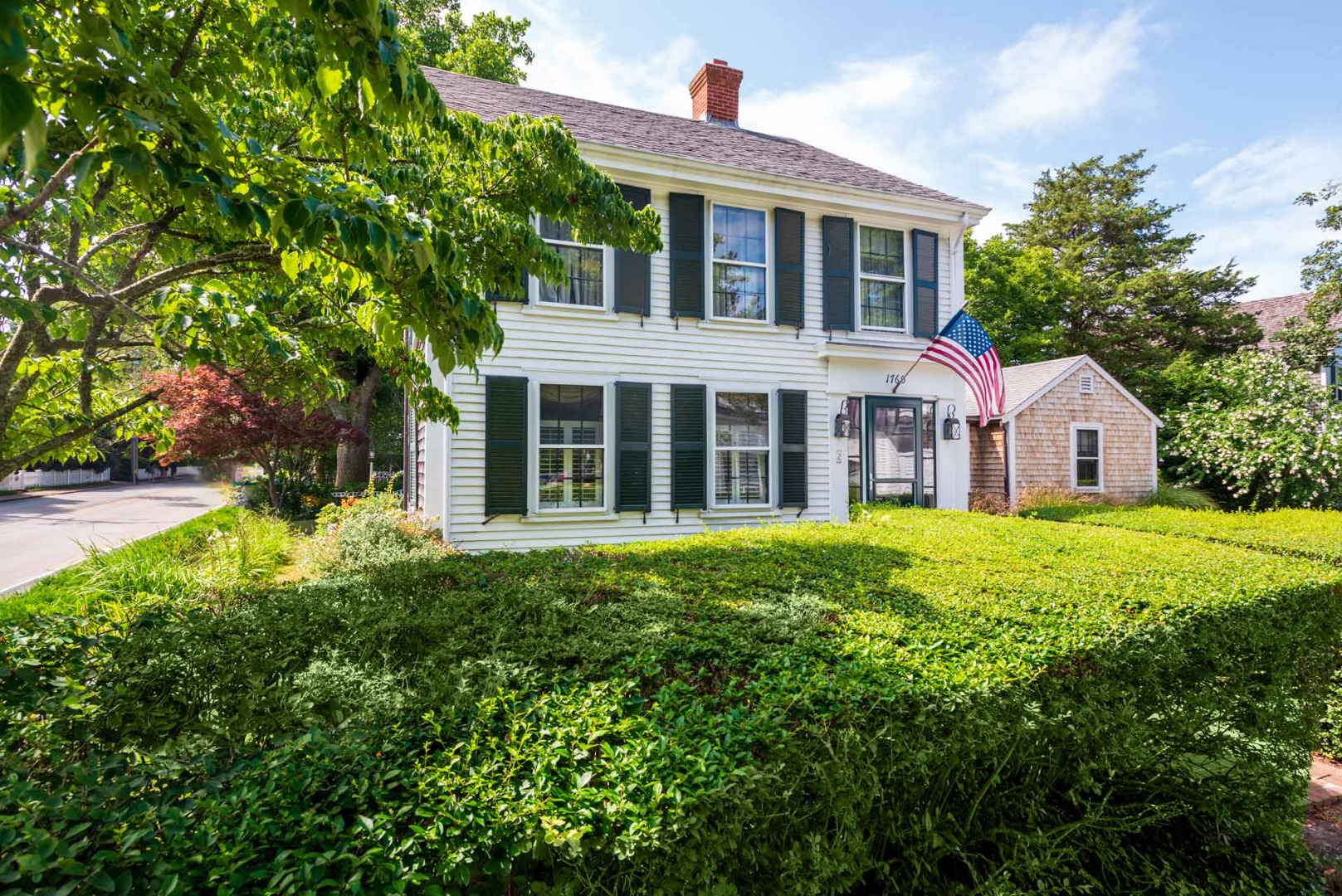 a front view of a house with yard and green space