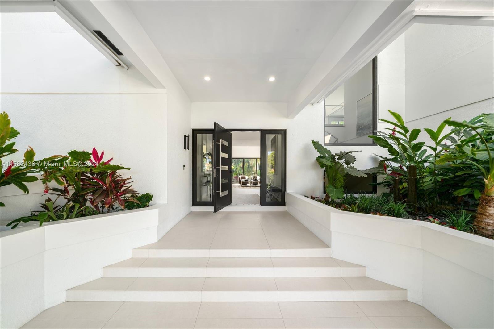 a lobby with a potted plant and floor to ceiling window