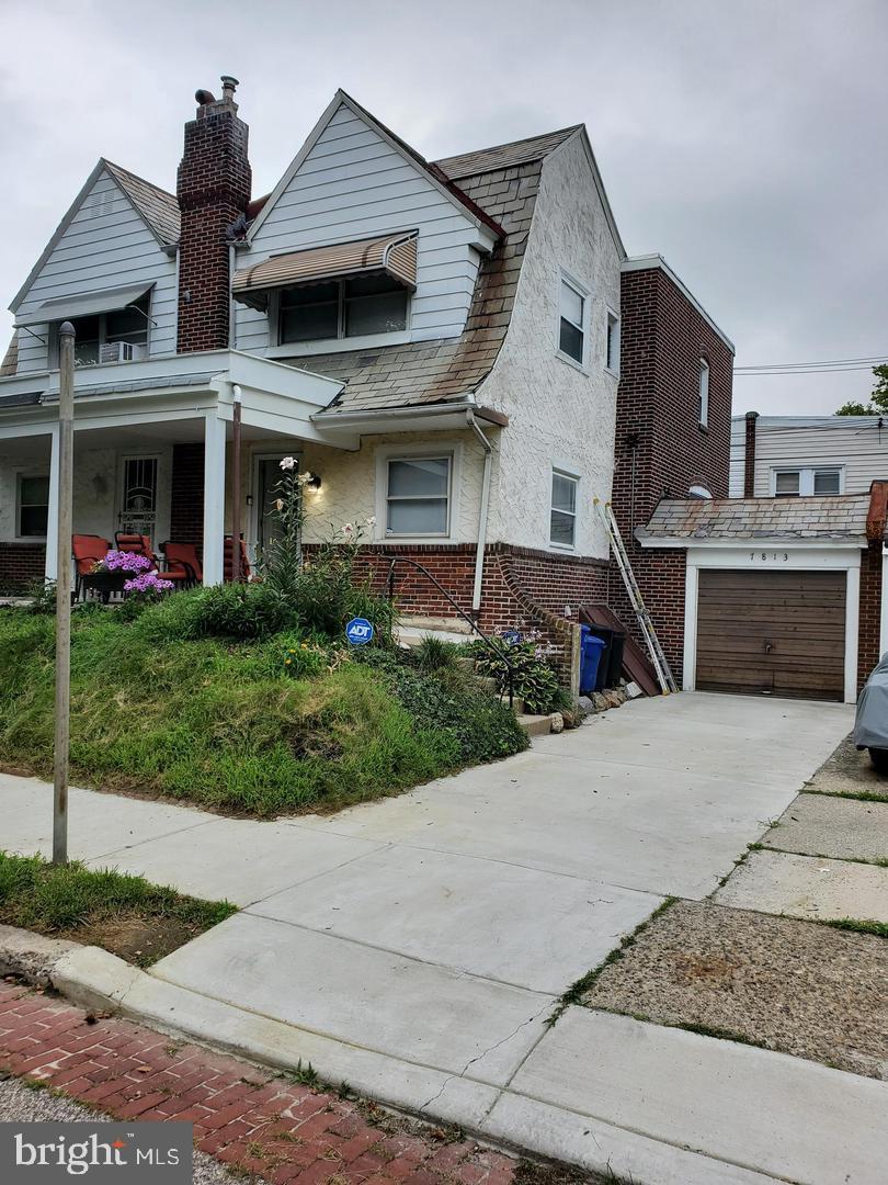 a front view of a house with a yard and potted plants