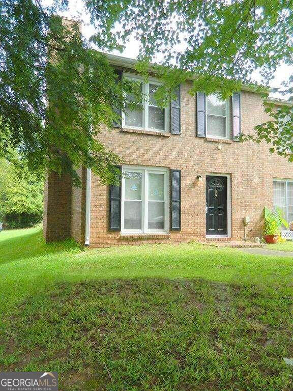 front view of a brick house with a yard