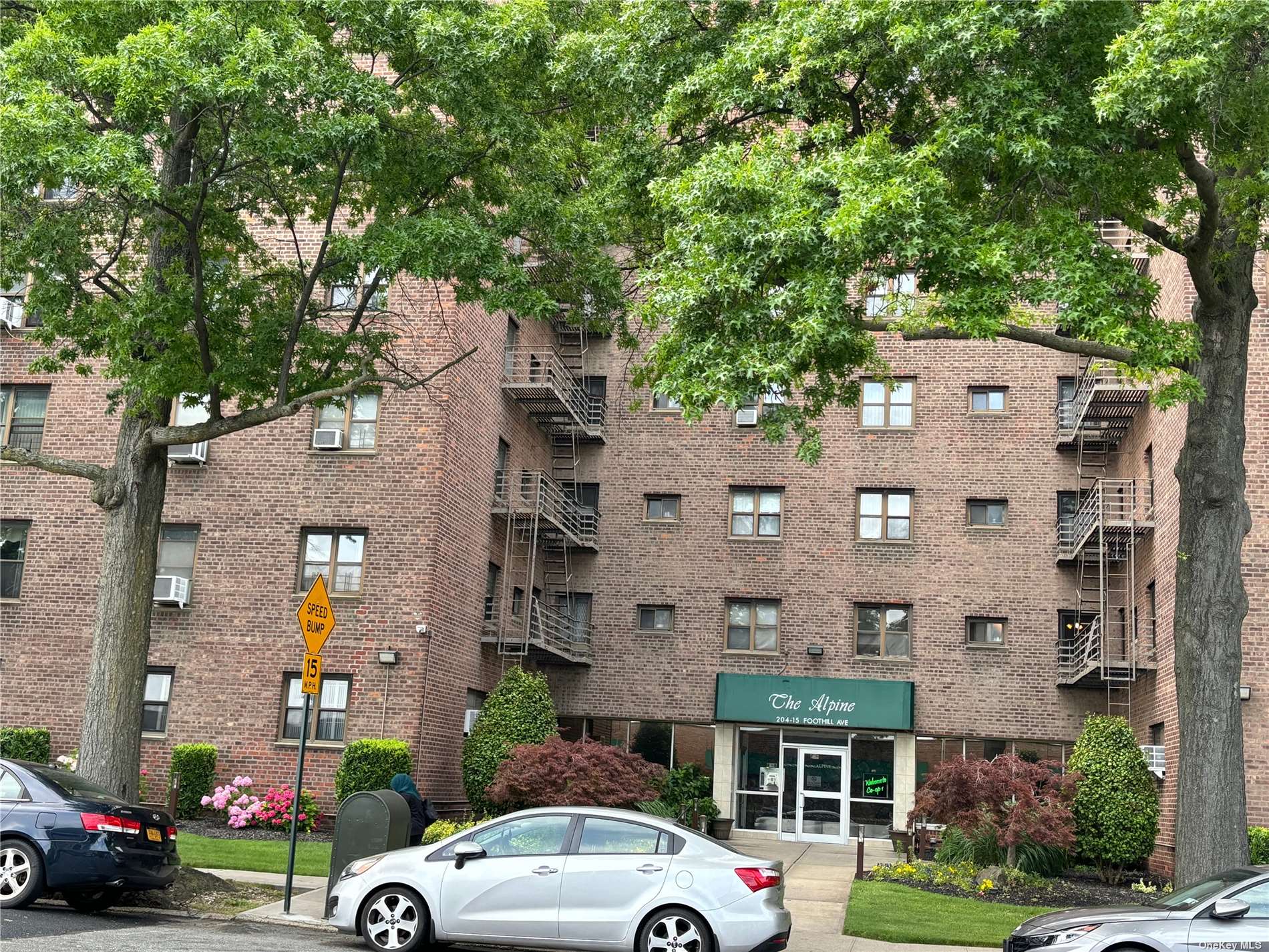 a view of building with cars parked across