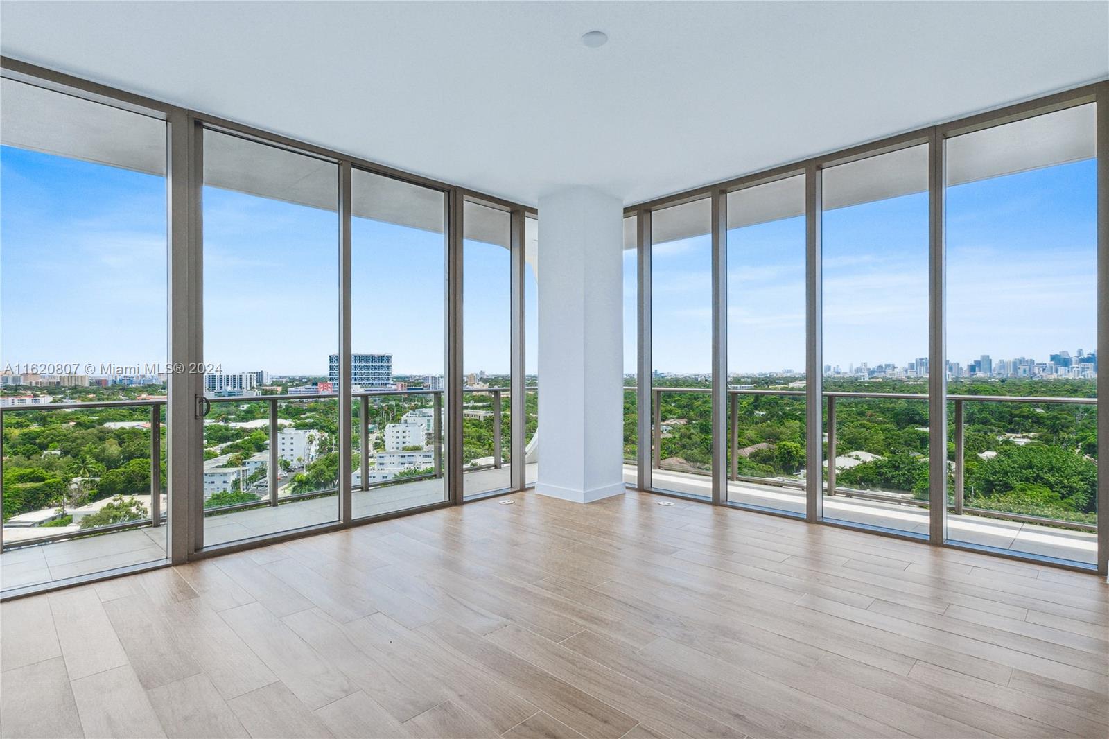 a view of an empty room with wooden floor and doors