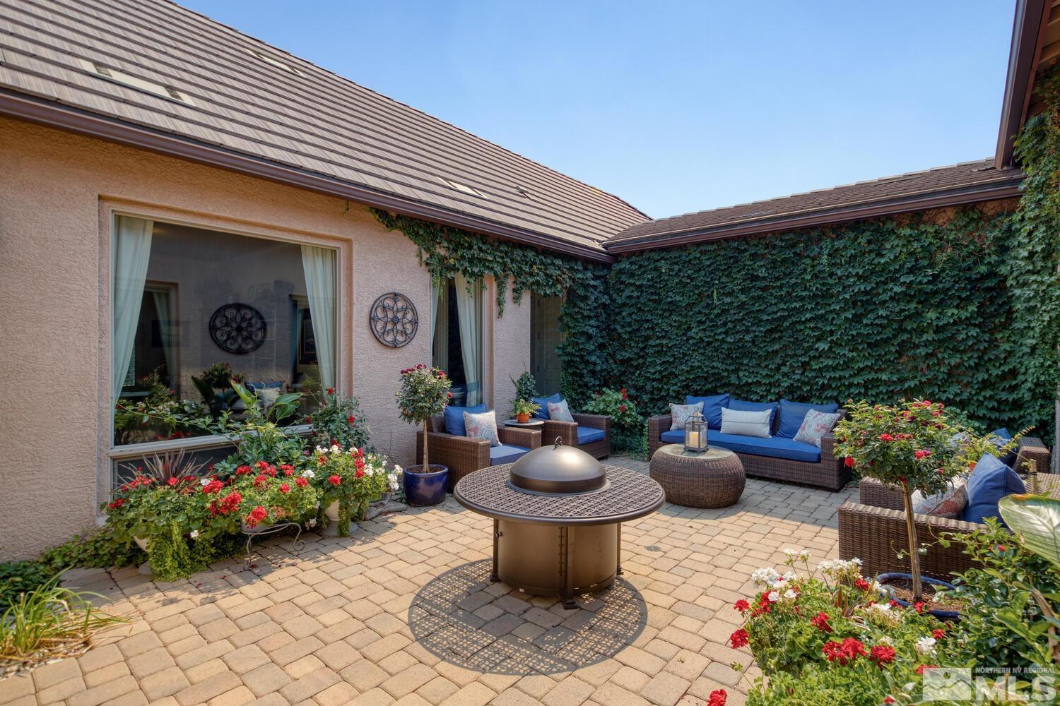 a view of a patio with chairs and potted plants