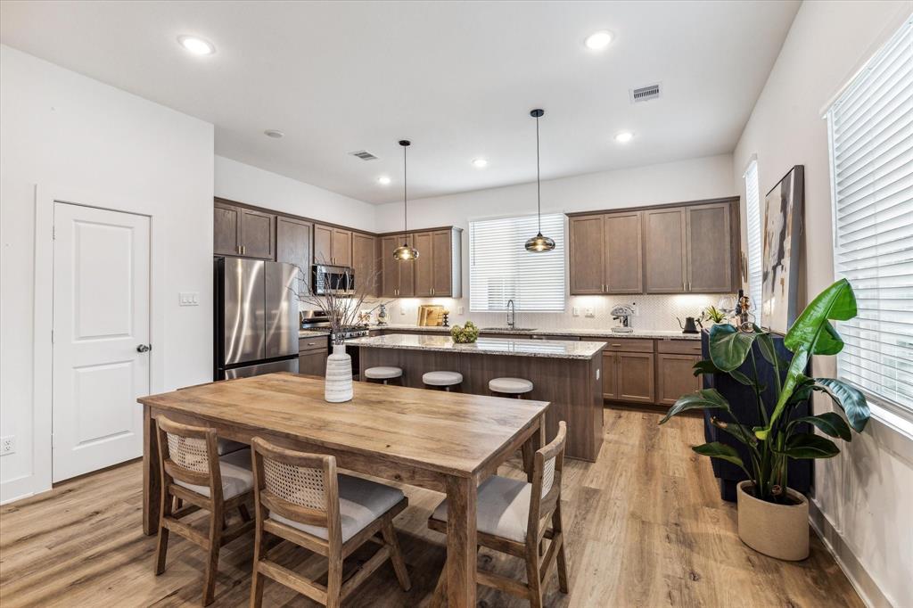 a kitchen with a table chairs refrigerator and microwave