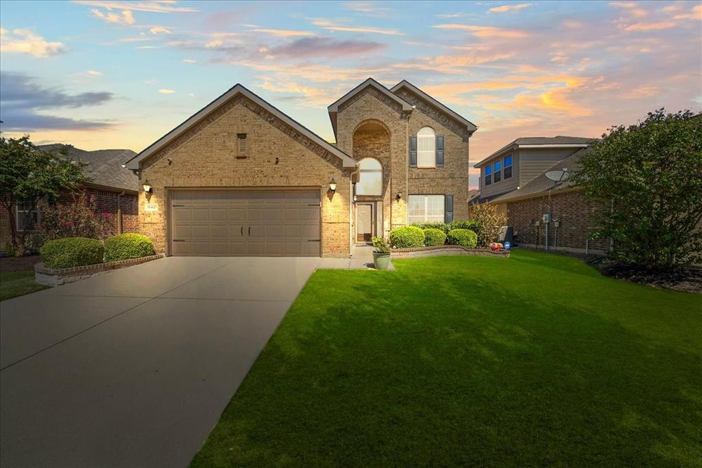 a front view of a house with a yard and garage