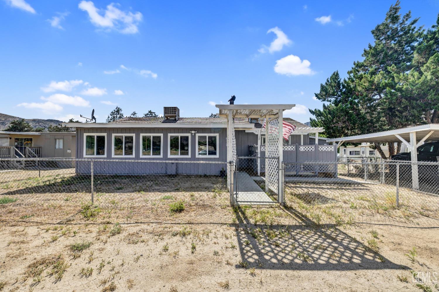 a view of a house with a wooden deck and a backyard