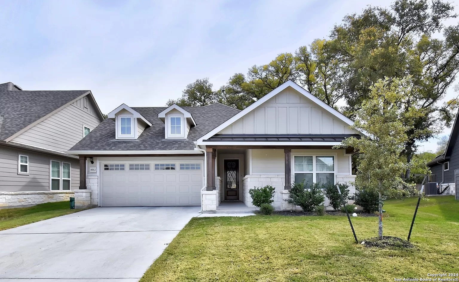 a front view of a house with a yard garage and outdoor seating