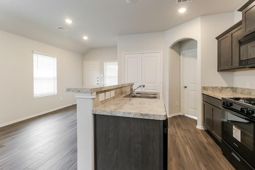 a kitchen with granite countertop a stove and a sink