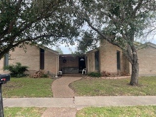 a front view of a house with a yard and tree