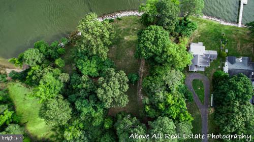 an aerial view of residential house with outdoor space and trees all around