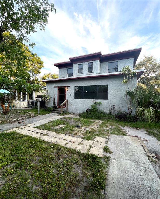 a view of a house with backyard and sitting area