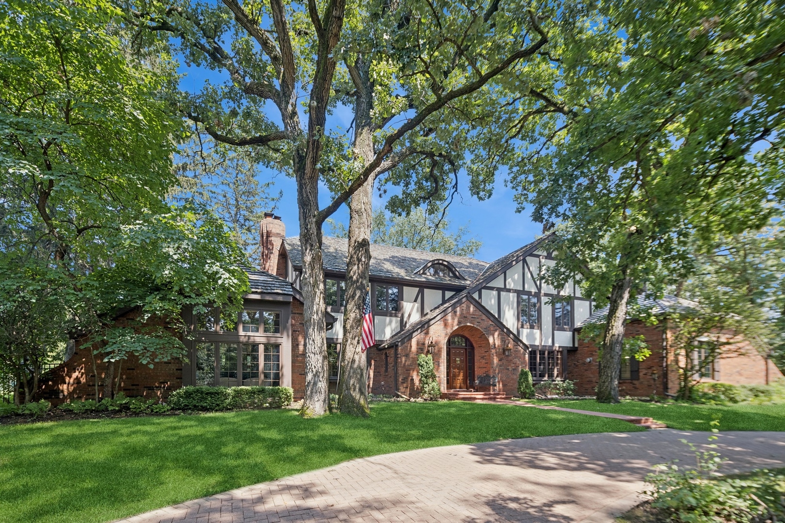 a view of a large house with a big yard and large trees