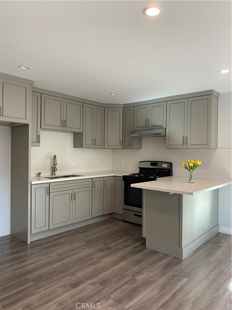 a kitchen with a sink a stove and cabinets