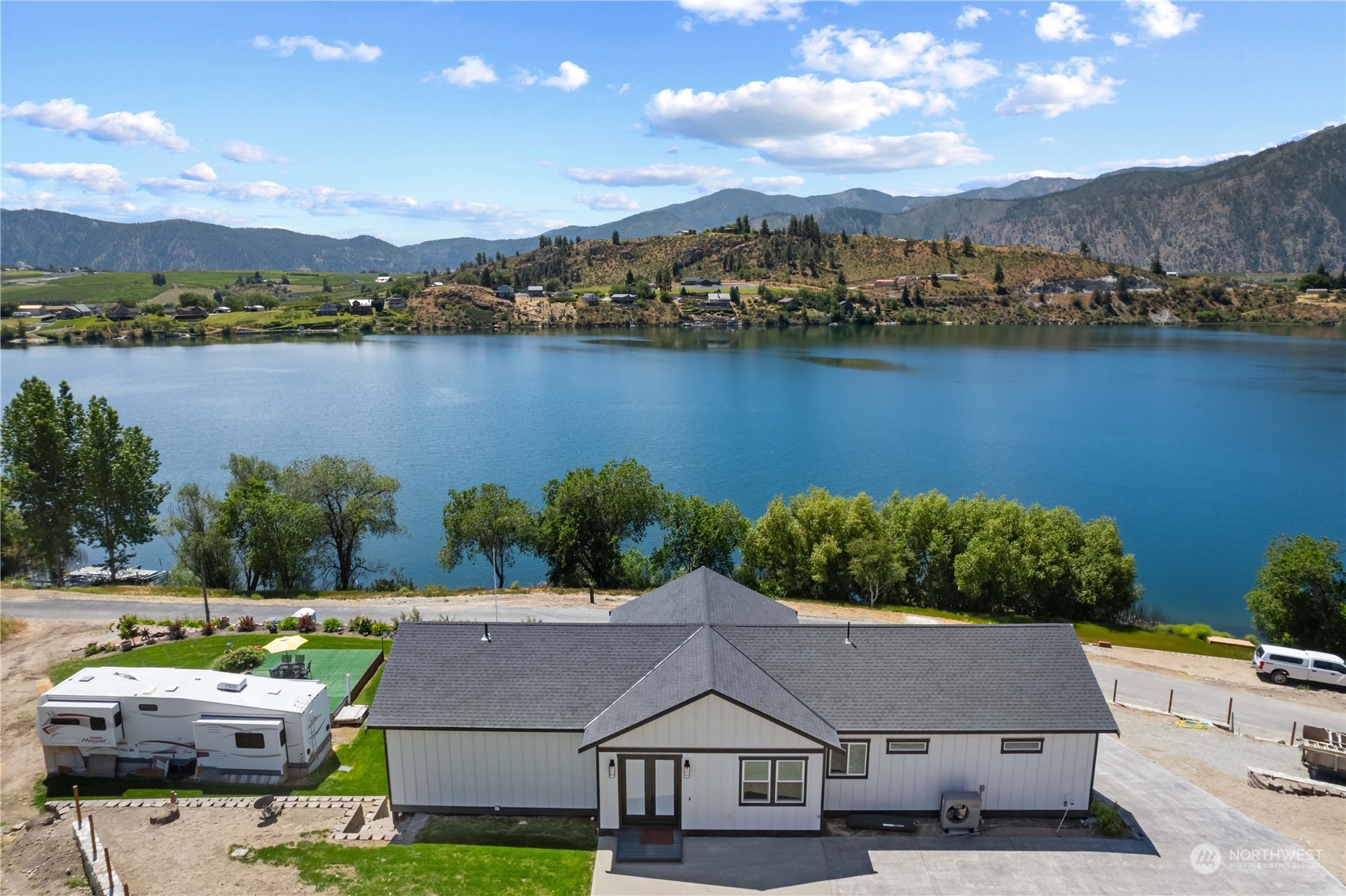 an aerial view of residential houses with outdoor space and lake view