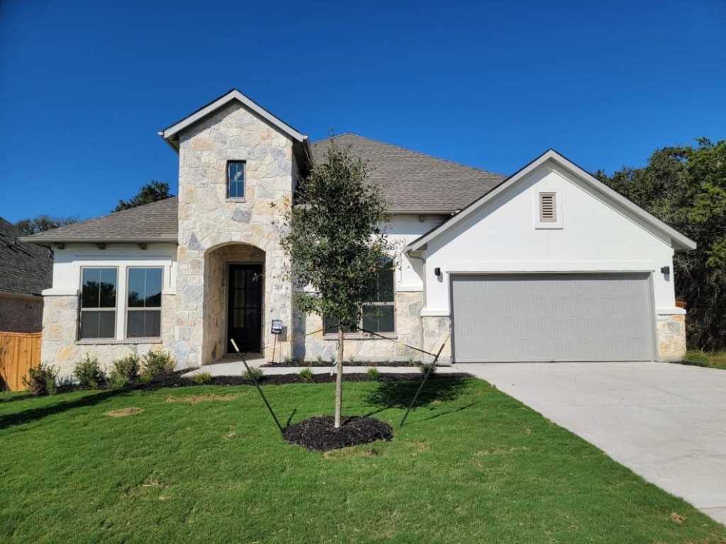 a front view of a house with a yard and garage