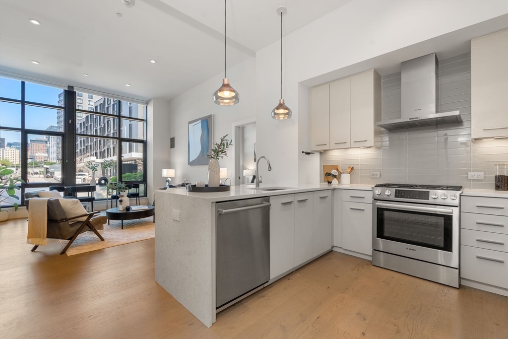 a kitchen with a stove cabinets and living room view