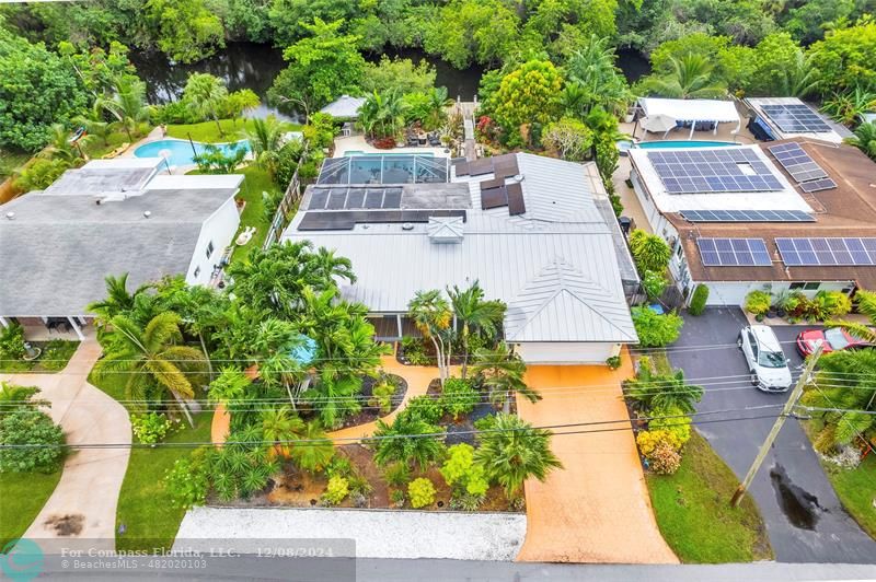 an aerial view of a house with a yard and large trees