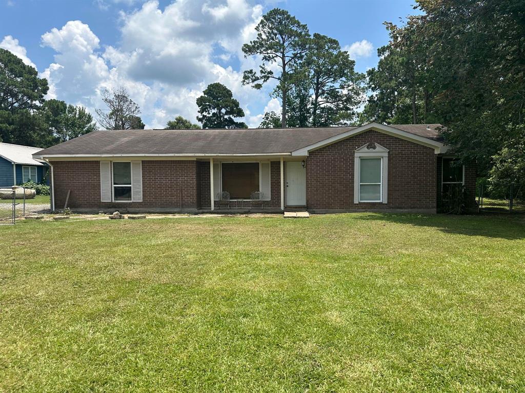 a front view of house with yard and trees around