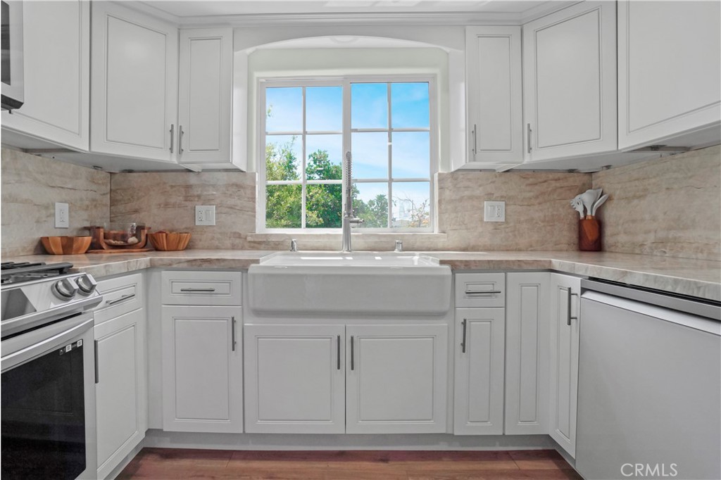 a kitchen with granite countertop white cabinets and a window