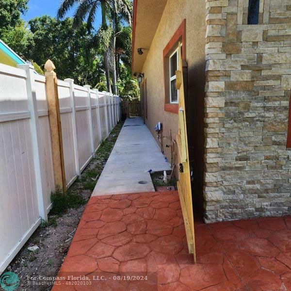 a view of a pathway of a building with wooden fence