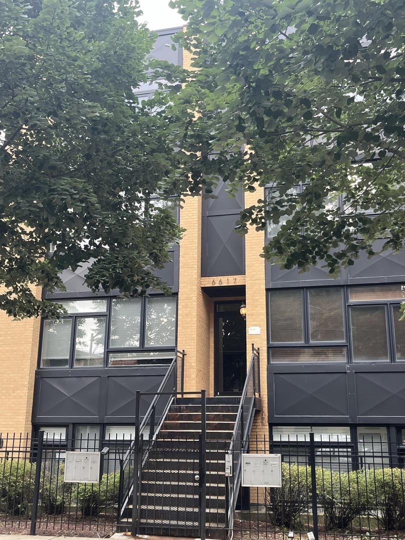 a front view of a house with a tree