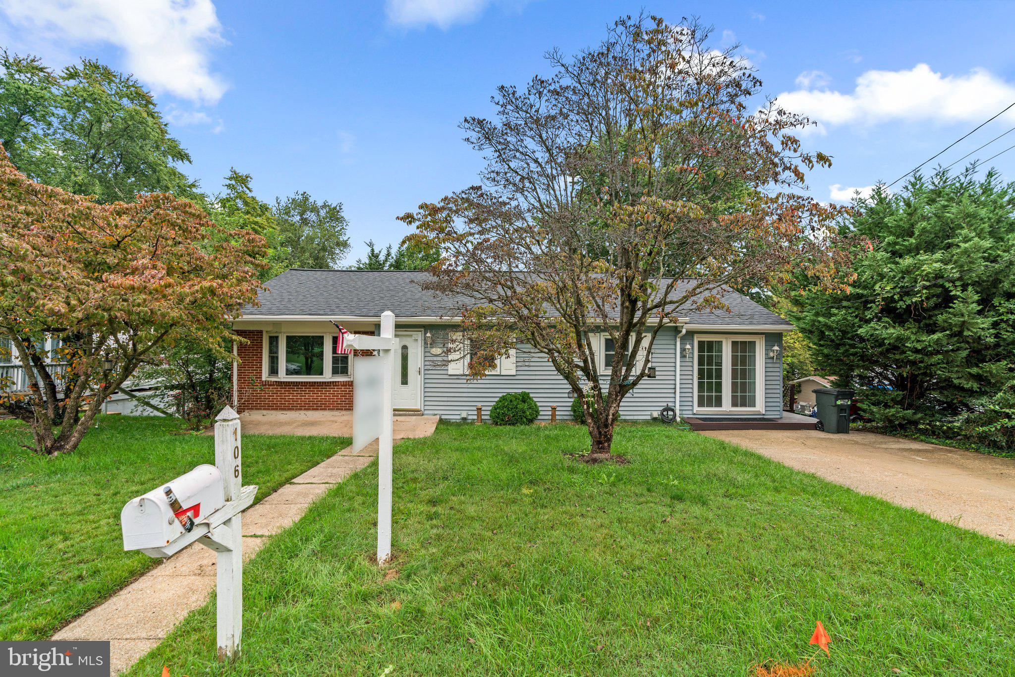 a front view of a house with a yard and trees