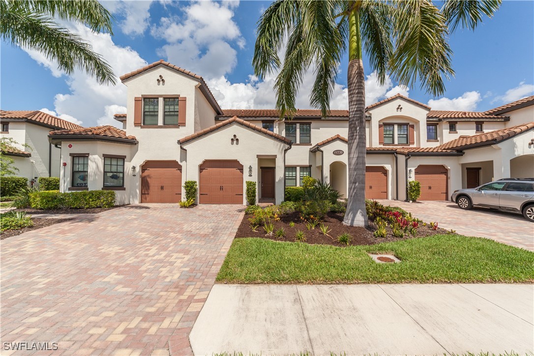 a front view of a house with a yard and palm tree