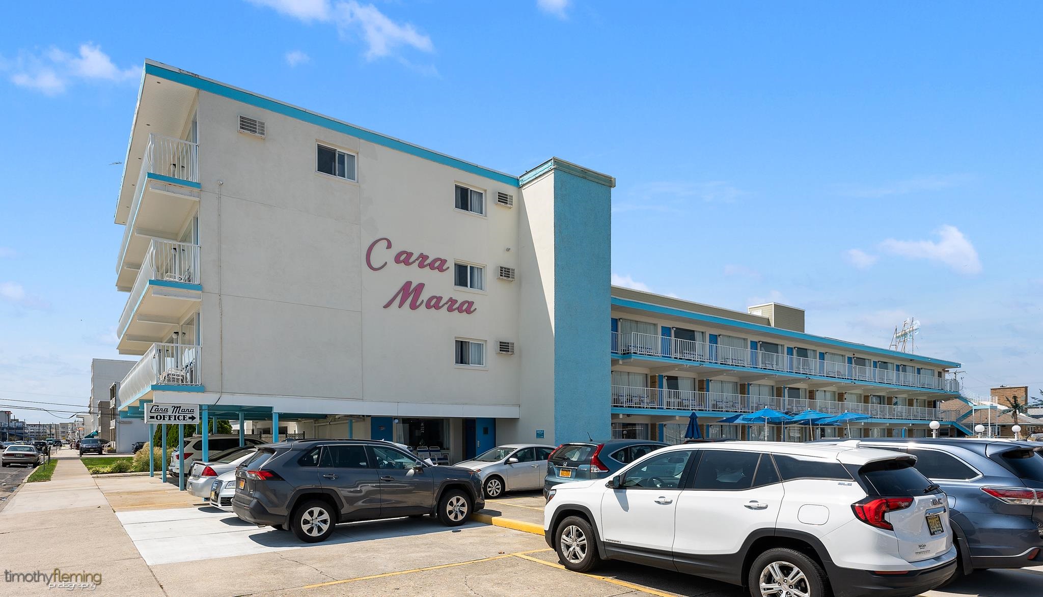 a front view of a building with cars parked