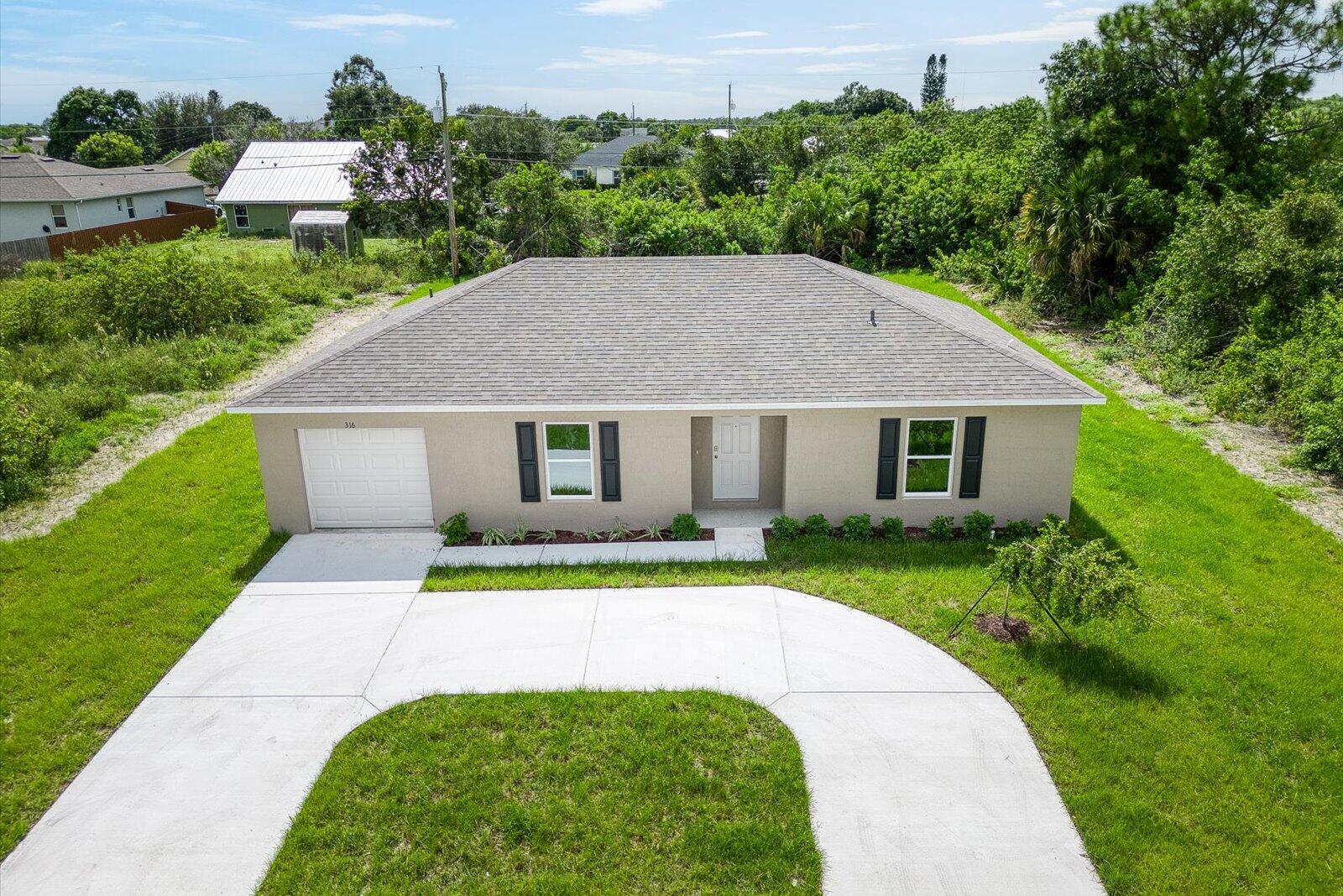 a aerial view of a house with a yard and potted plants