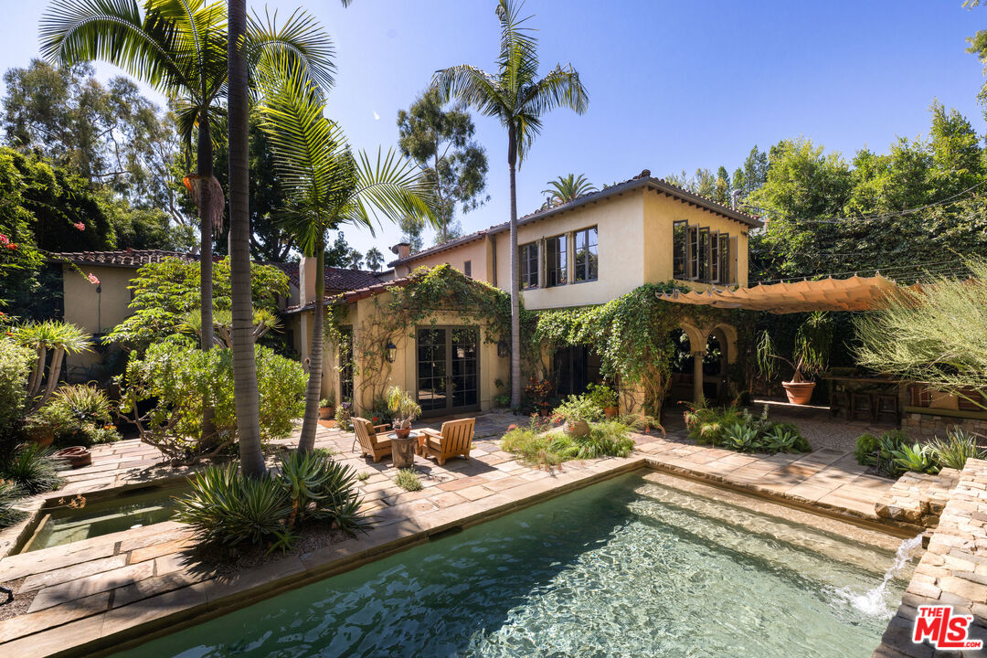 a front view of a house with a yard garden and patio