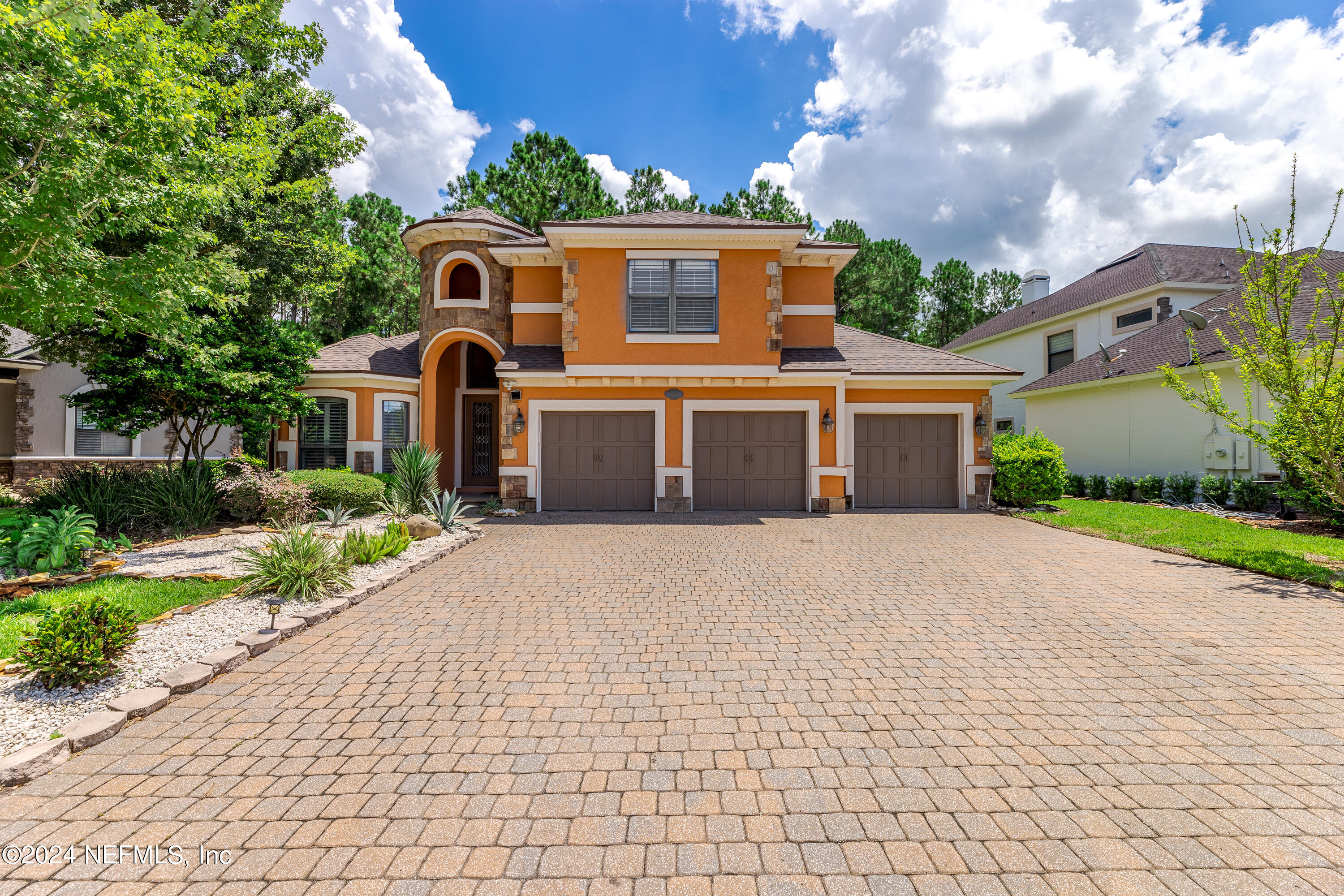 a front view of a house with a yard and a garden