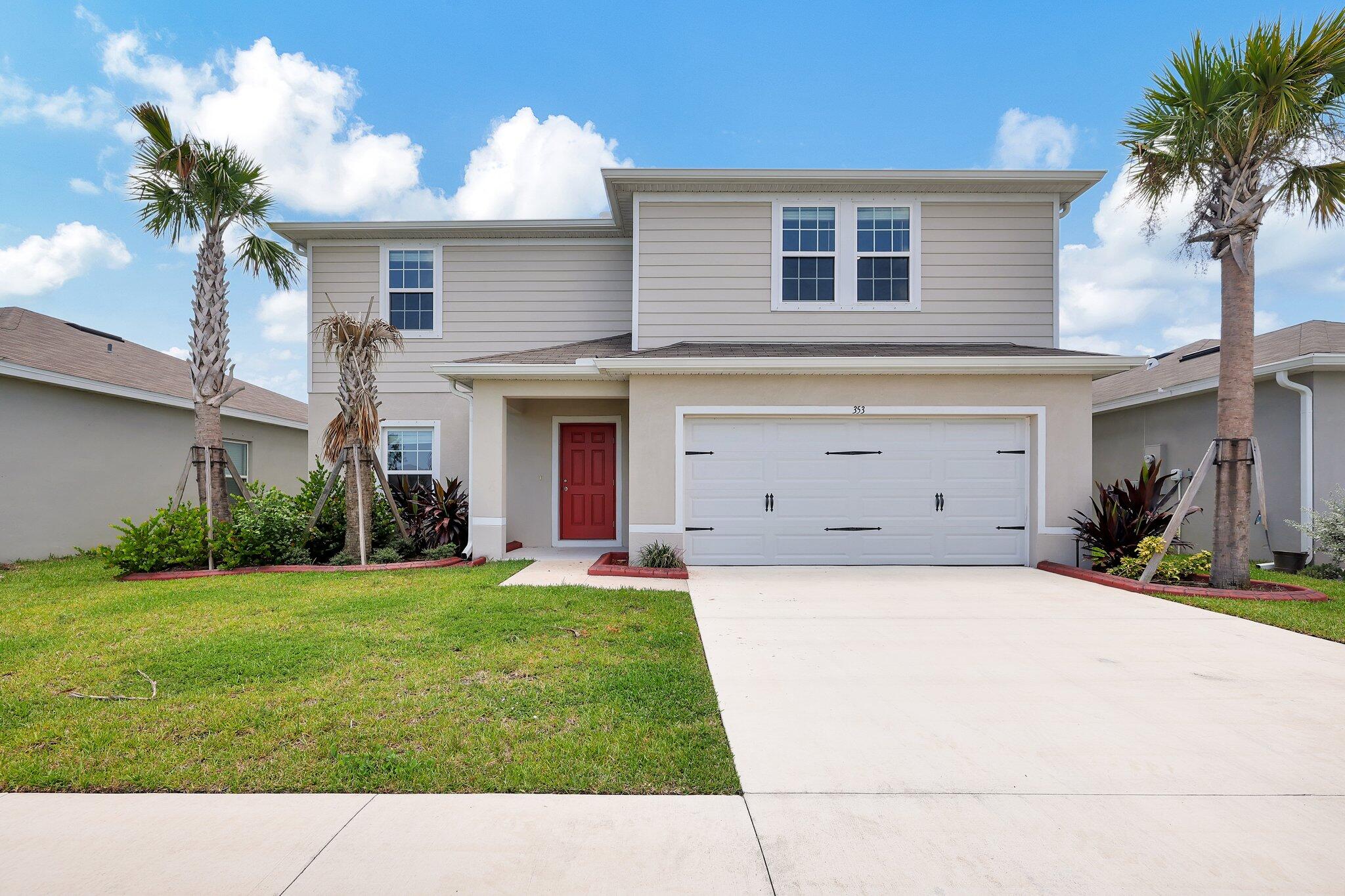 a front view of a house with a yard and garage