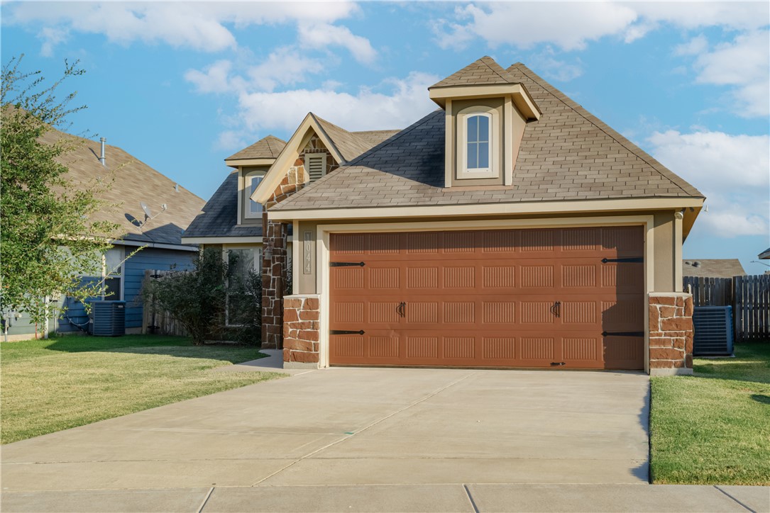 View of front of house with a garage, a front lawn