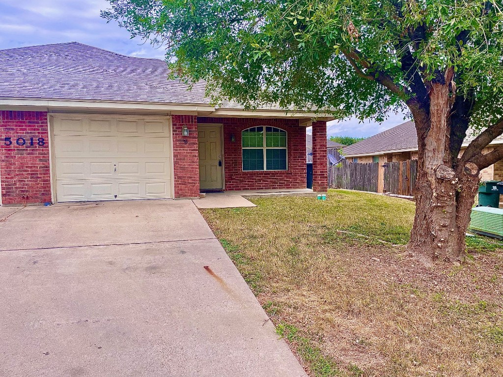 front view of a house with a tree