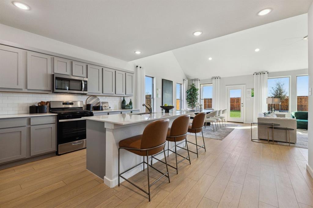 a kitchen with a sink cabinets and wooden floor