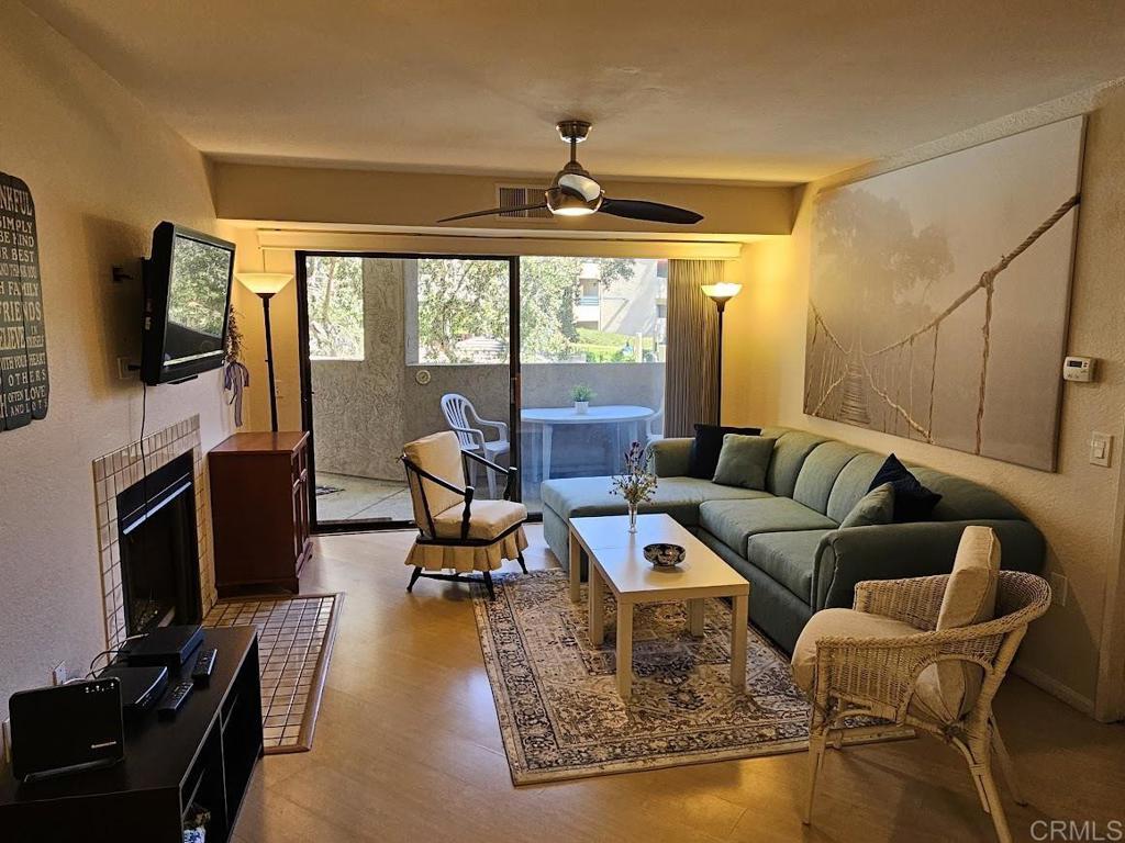 a living room with furniture a flat screen tv and a fireplace