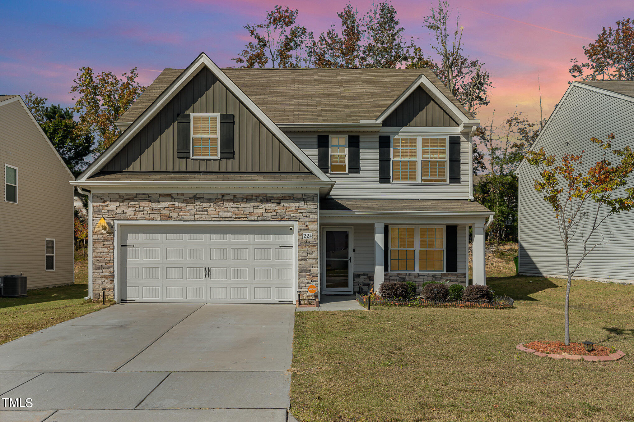 a front view of a house with a yard and garage