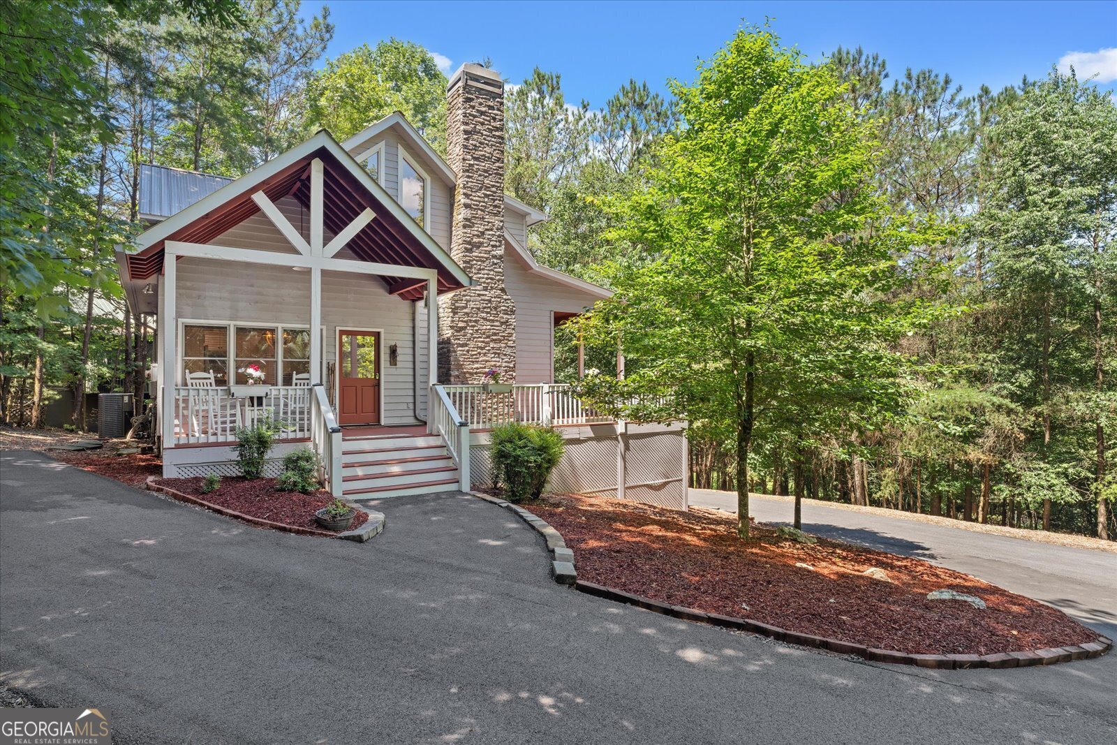 a view of a house with a yard and large tree