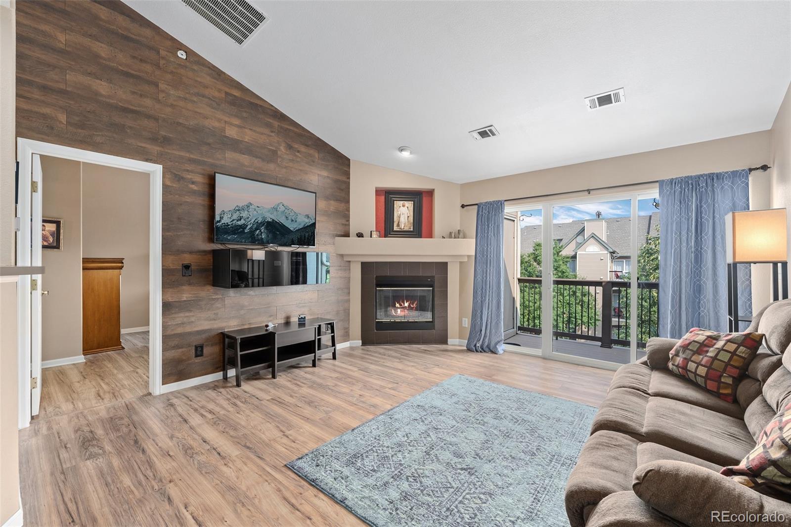 a living room with furniture large window and a fireplace